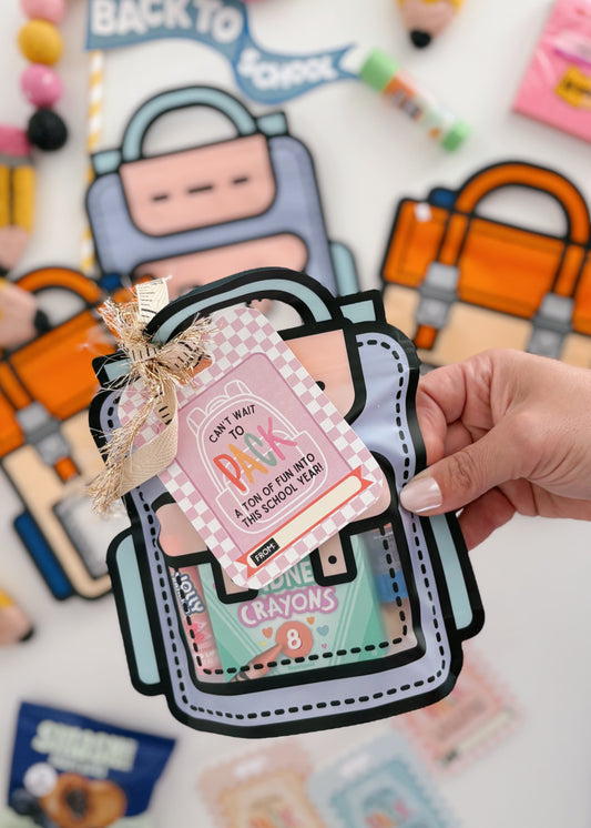 Back-to-school themed card with a backpack design held by a hand, surrounded by colorful stationery items.